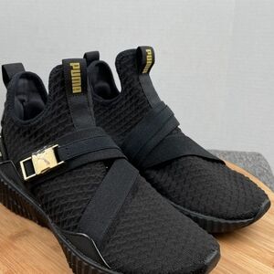 black PUMA Defy Mid women's training shoes with gold accents. Size 8